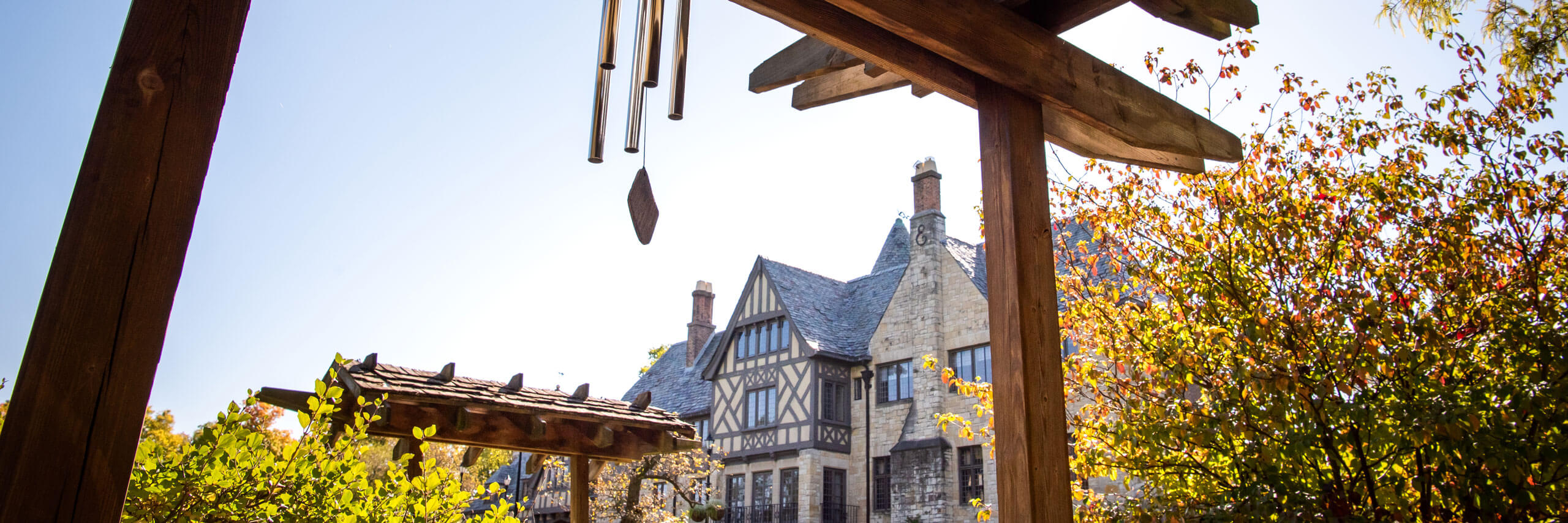 A shot of Ewing Manor with a trellis and windchimes in the foreground.