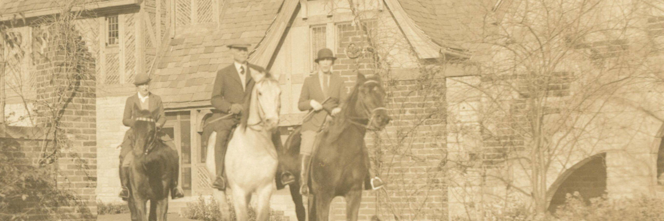 Hazle Buck Ewing, Julia Hodges, and Alfred Klotts sit atop their horses at the gate of the manor.