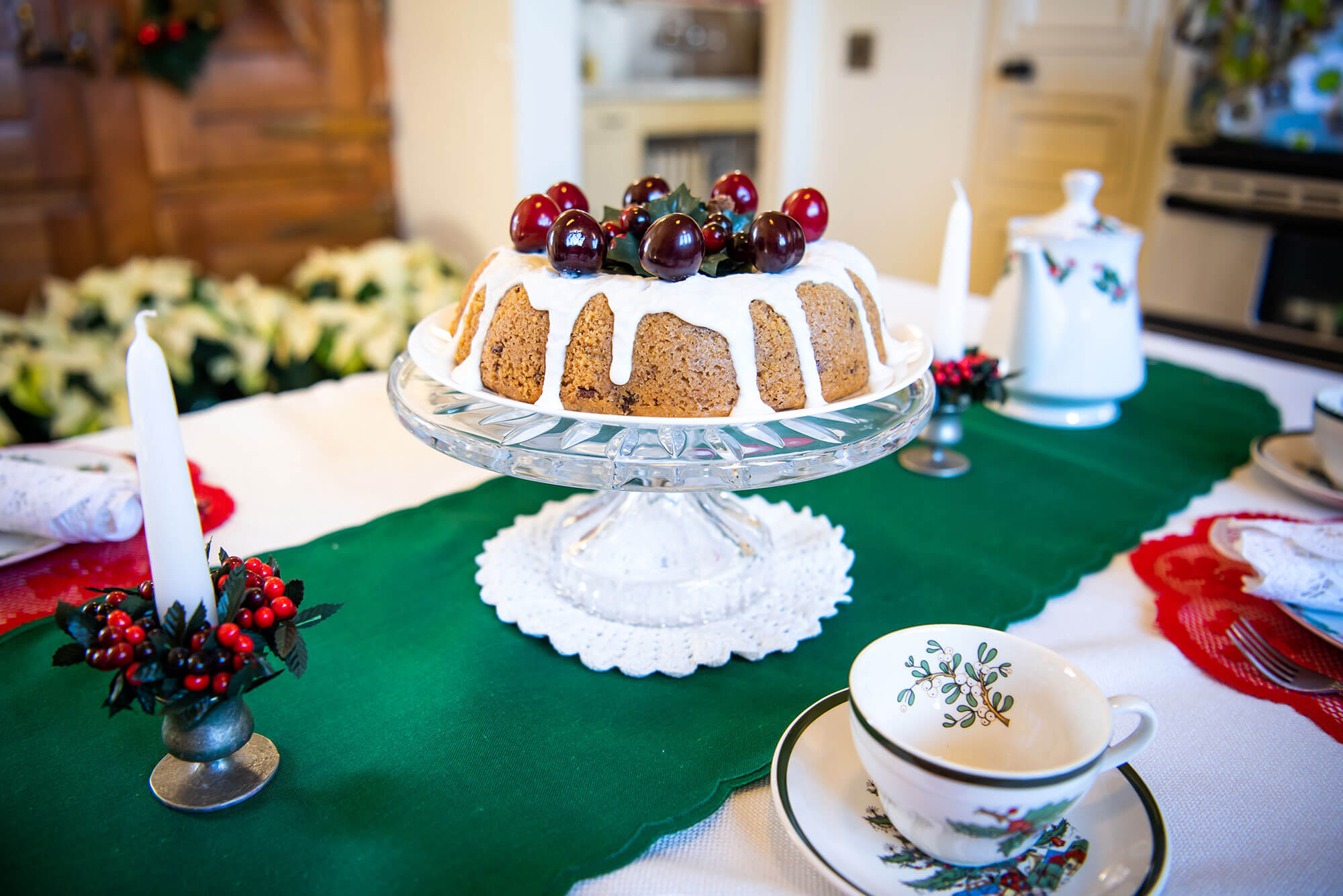 A cake on a table decorated with Christmas ornaments.