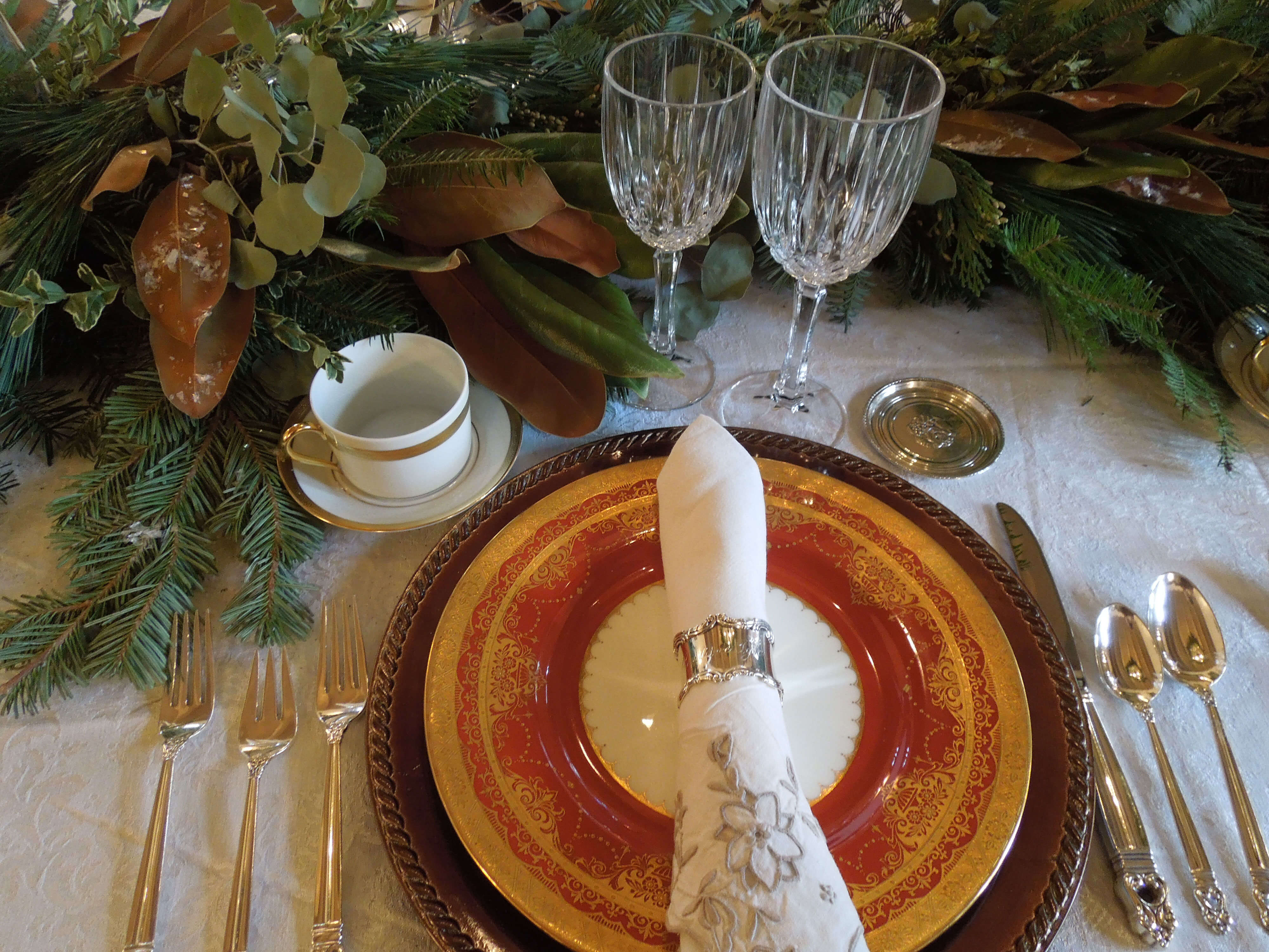 Decorated table with plates, plants, and silverware.