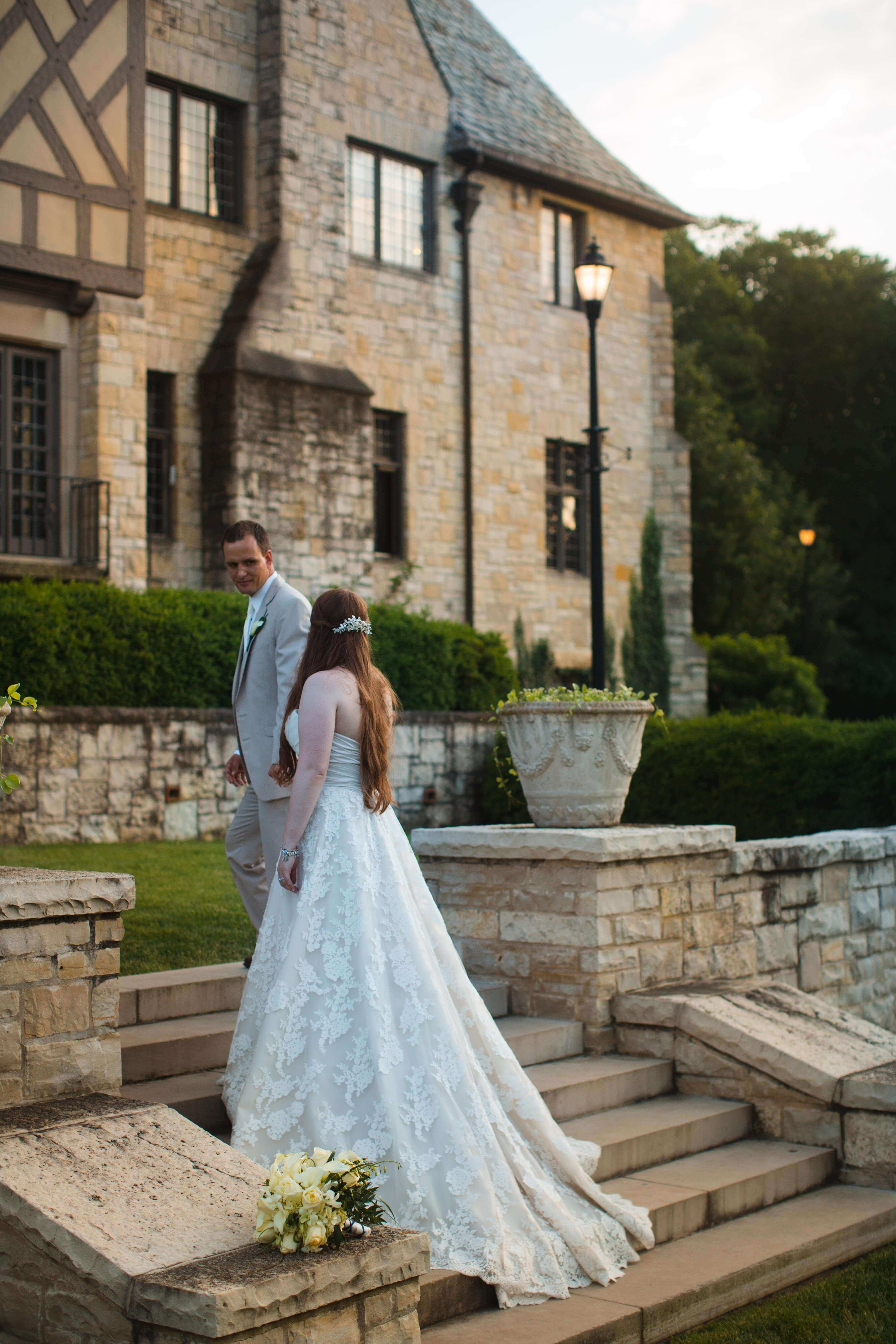 Bride and groom going upstairs outside of the Manor.